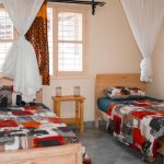 Inviting twin bedroom in Kampala, featuring vibrant bedspreads and a peaceful ambiance.