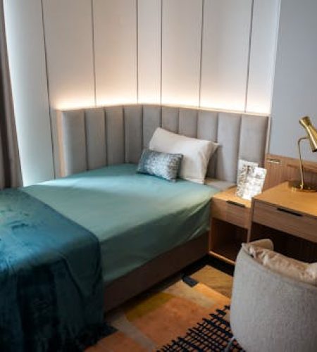 Chic modern bedroom featuring a single bed, wooden desk, and stylish decor.